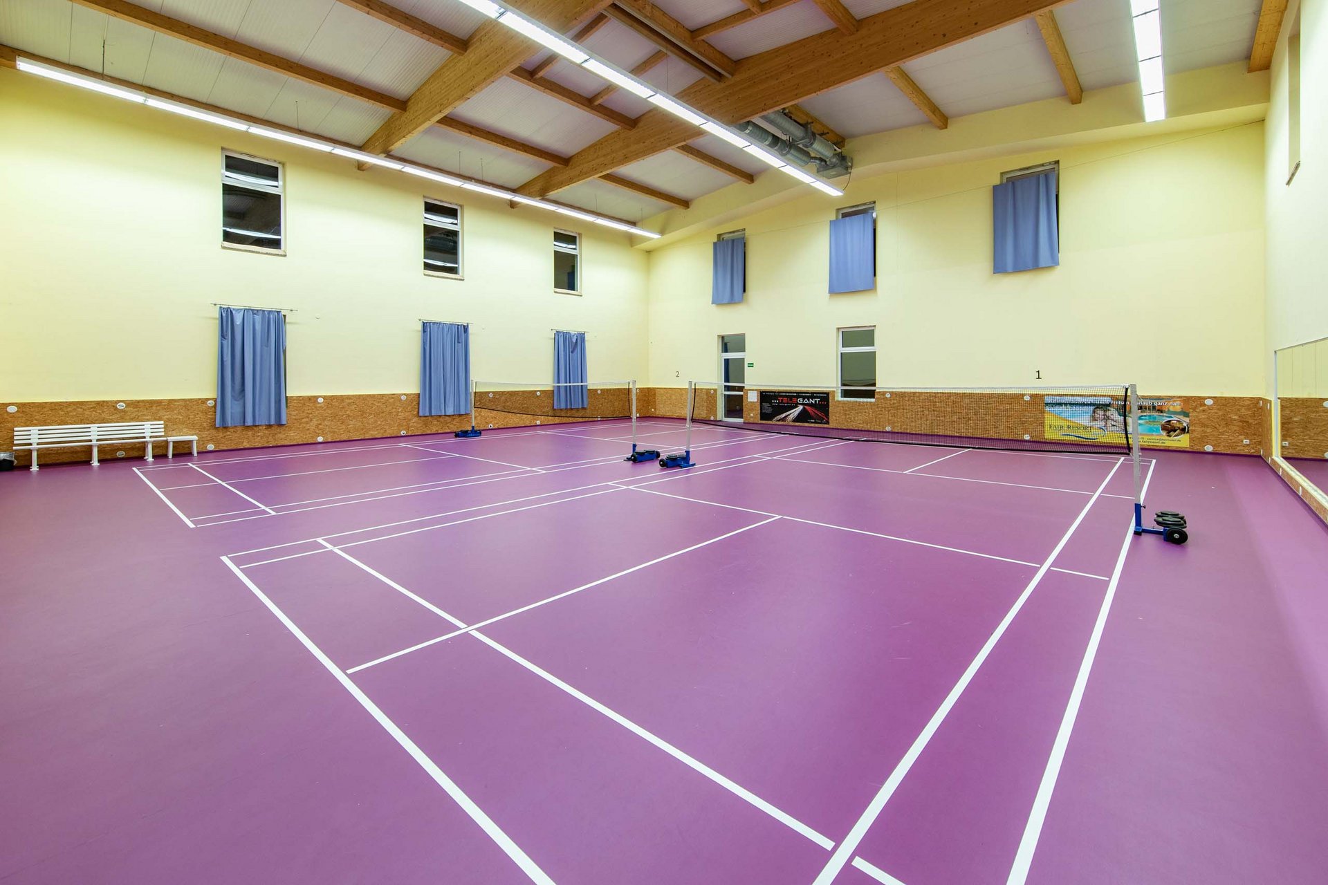 2V8A1128.jpg Leerer Badminton-Spielfeldboden mit violettem Belag in einer Halle