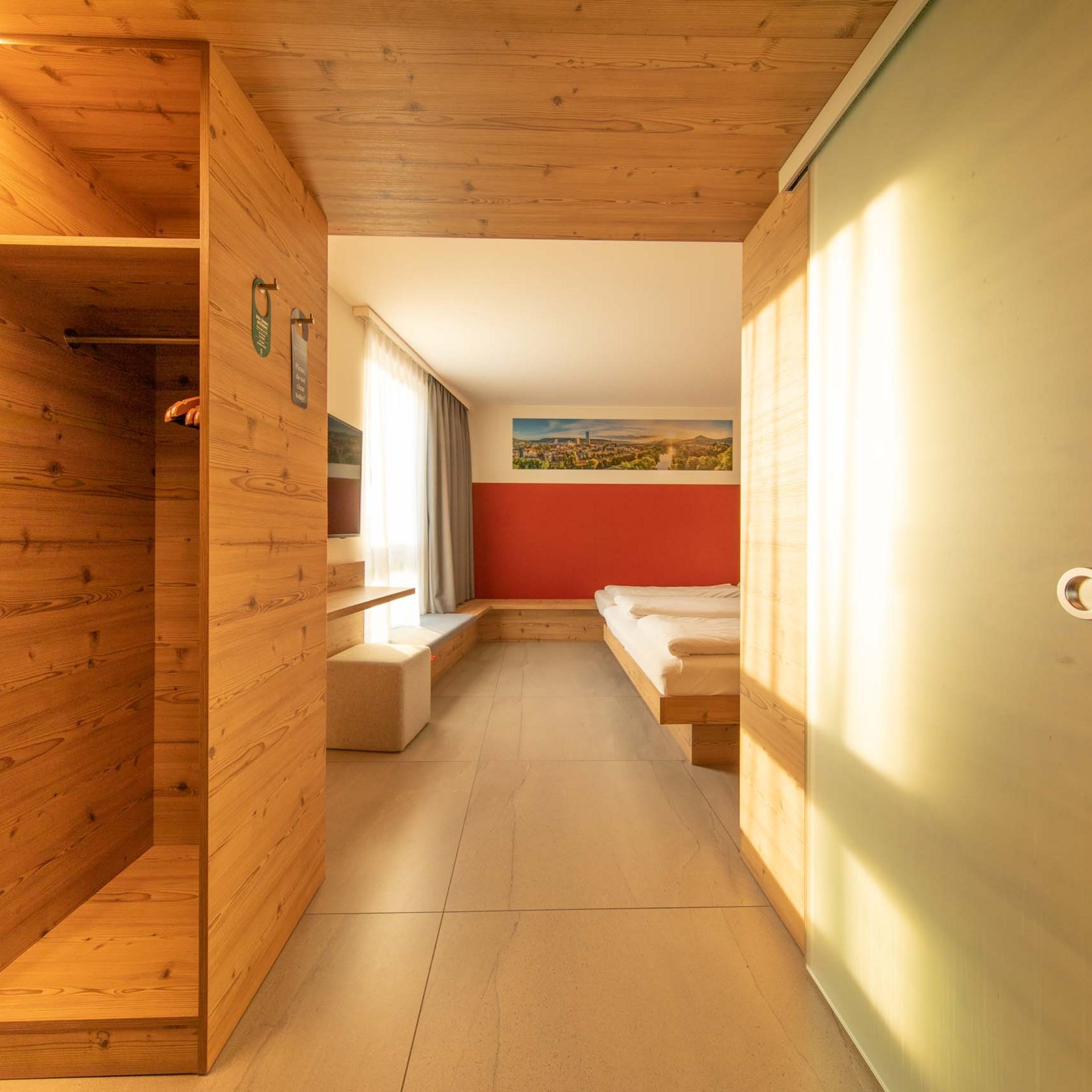 Dreibettzimmer Helle Hotelzimmer mit Holzvertäfelung und modernen Möbeln