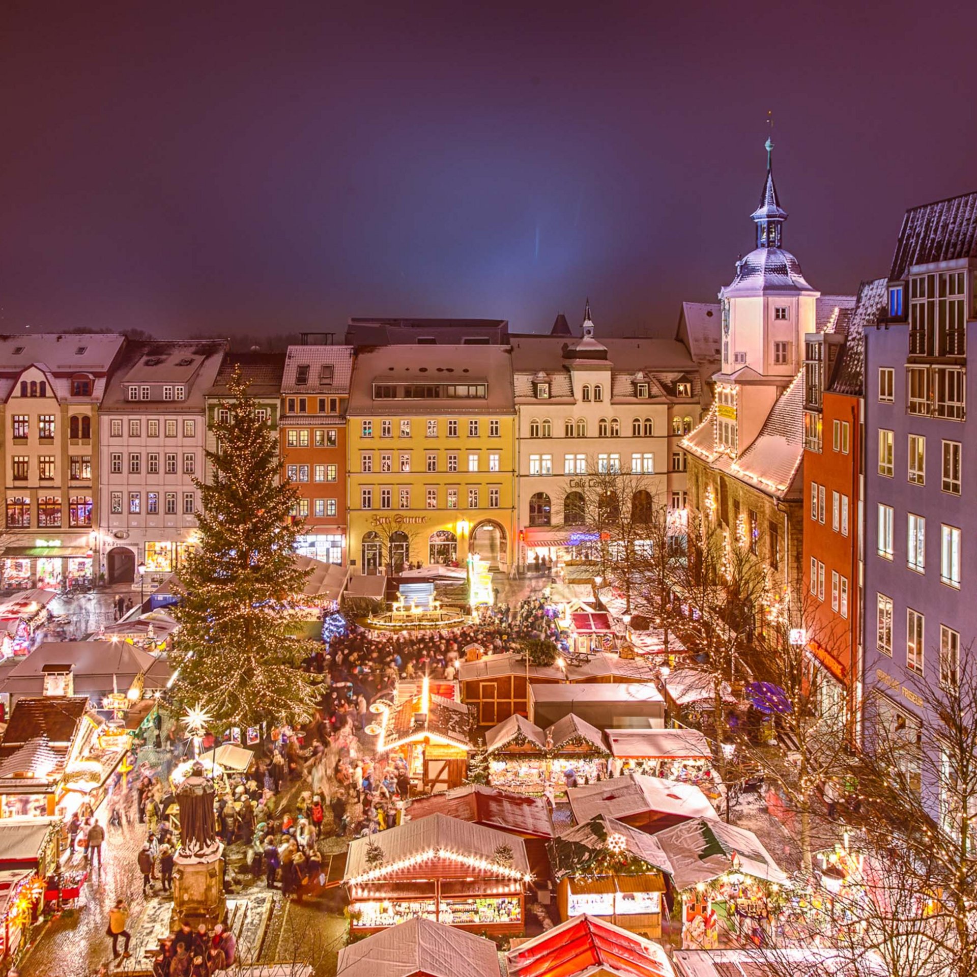 Sehenswürdigkeiten in und um Jena Abendlicher Weihnachtsmarkt mit beleuchtetem Tannenbaum und historischen Gebäuden
