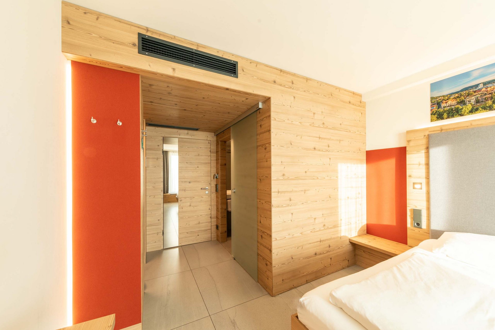 Nature Helles Hotelzimmer mit Holzwänden, rotem Akzent und weißem Bett