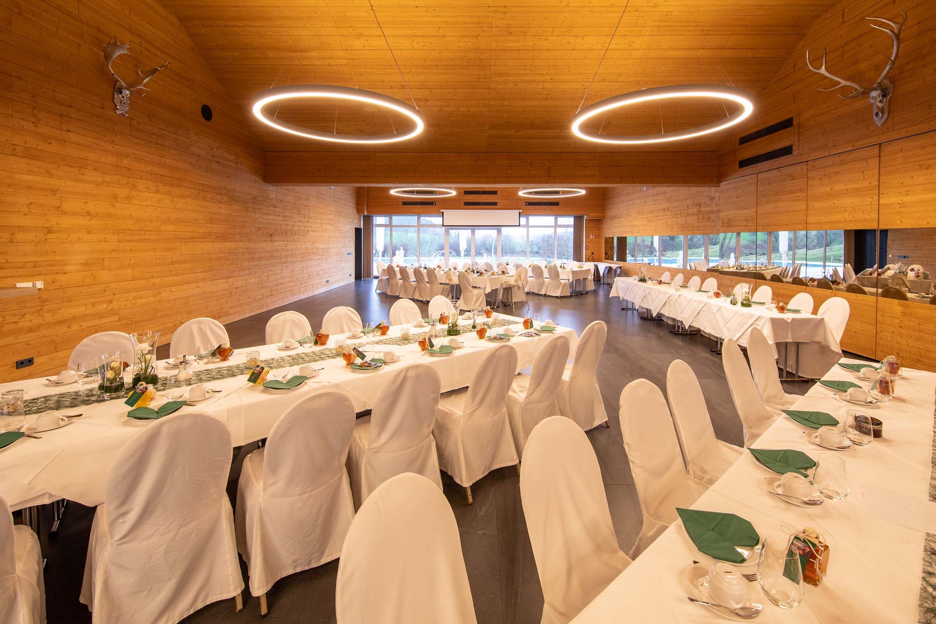 Urlaub in Jena: mein Fair Resort Festlich gedeckte Tische in einem großen, modernen Veranstaltungsraum mit Holzverkleidung