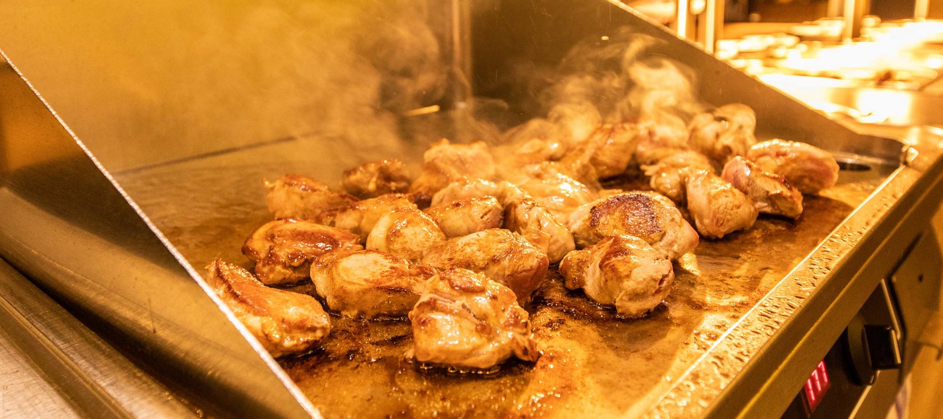 Ein Hotel in Jena mit All-inclusive-Verpflegung Hähnchenstücke werden auf einer heißen Grillplatte gebraten