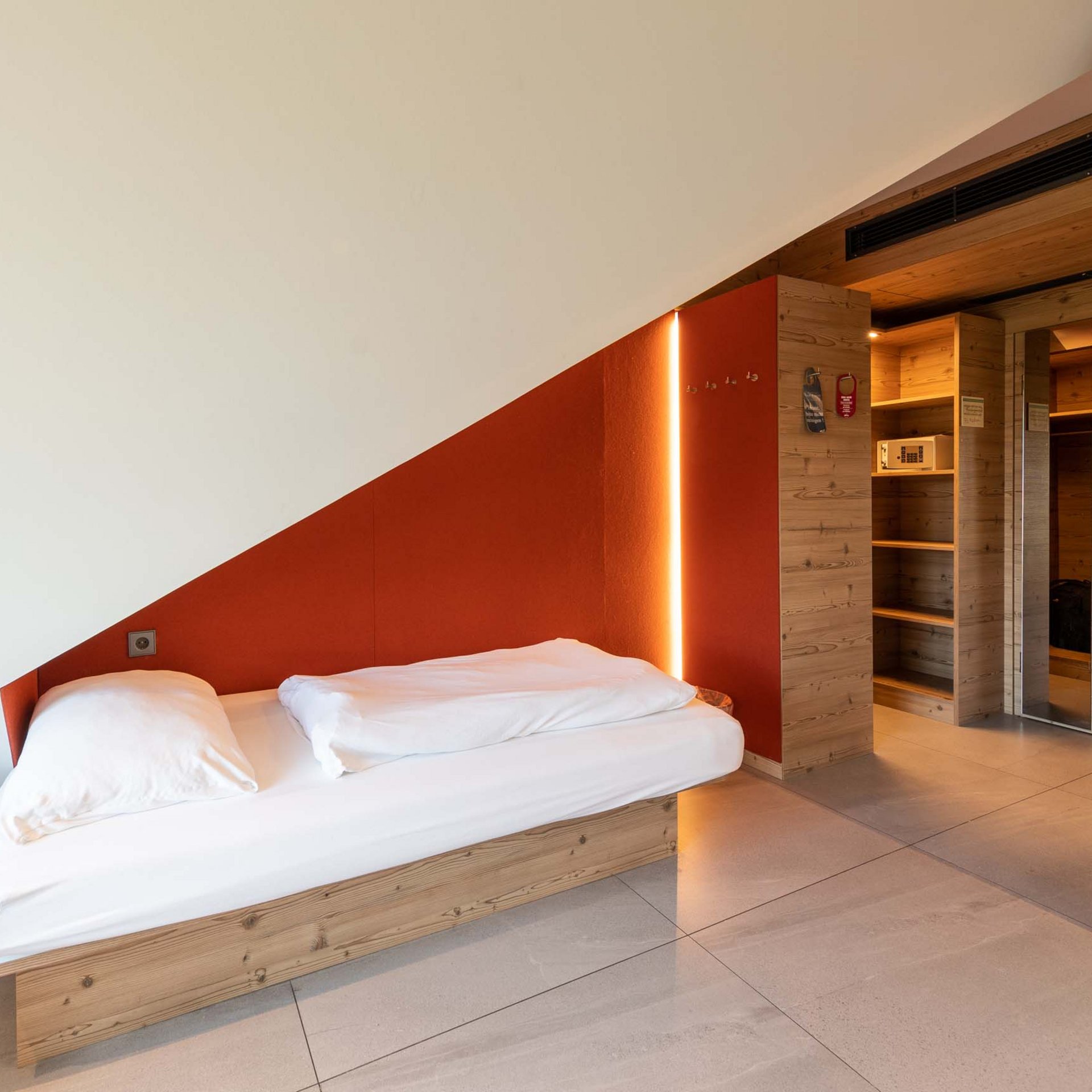Vierbettzimmer Modernes Hotelzimmer mit schräger Decke, Einzelbett und Holzverkleidung