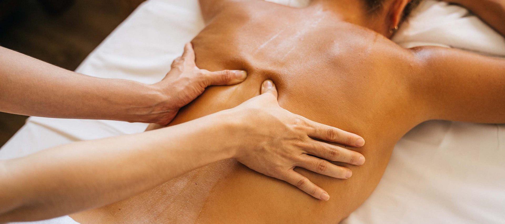 Day Spa in Jena: ein Tag nur für Sie Person erhält Rückenmassage auf weißer Liege