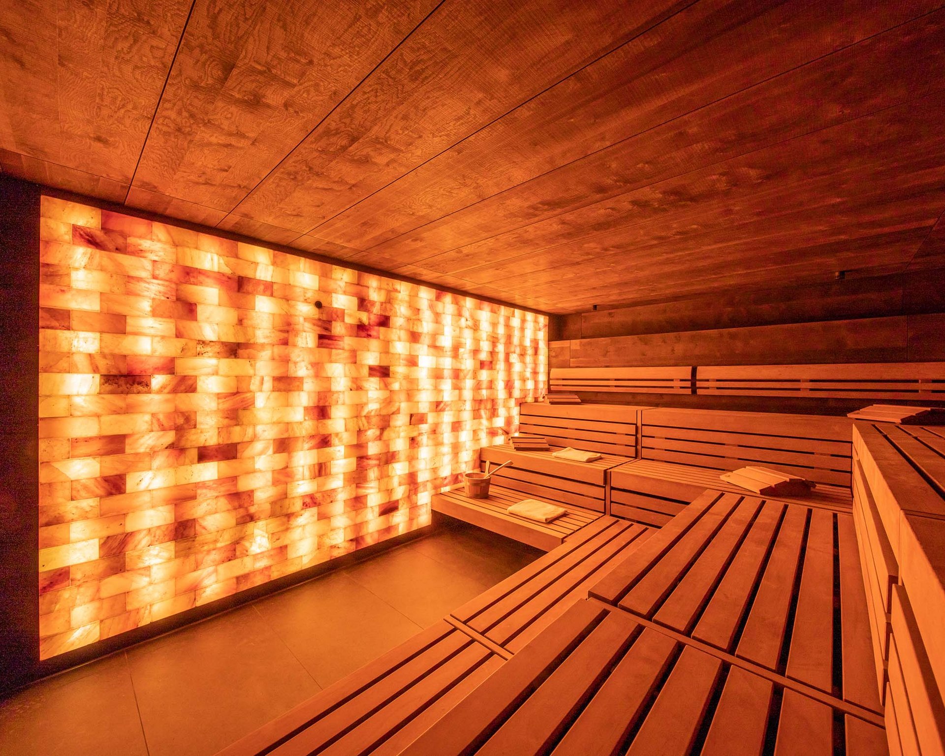 DAS Wellnesshotel in Thüringen: mit Schwimmbad … Innenansicht einer modernen Sauna mit Holzverkleidung und beleuchteter Salzsteinwand