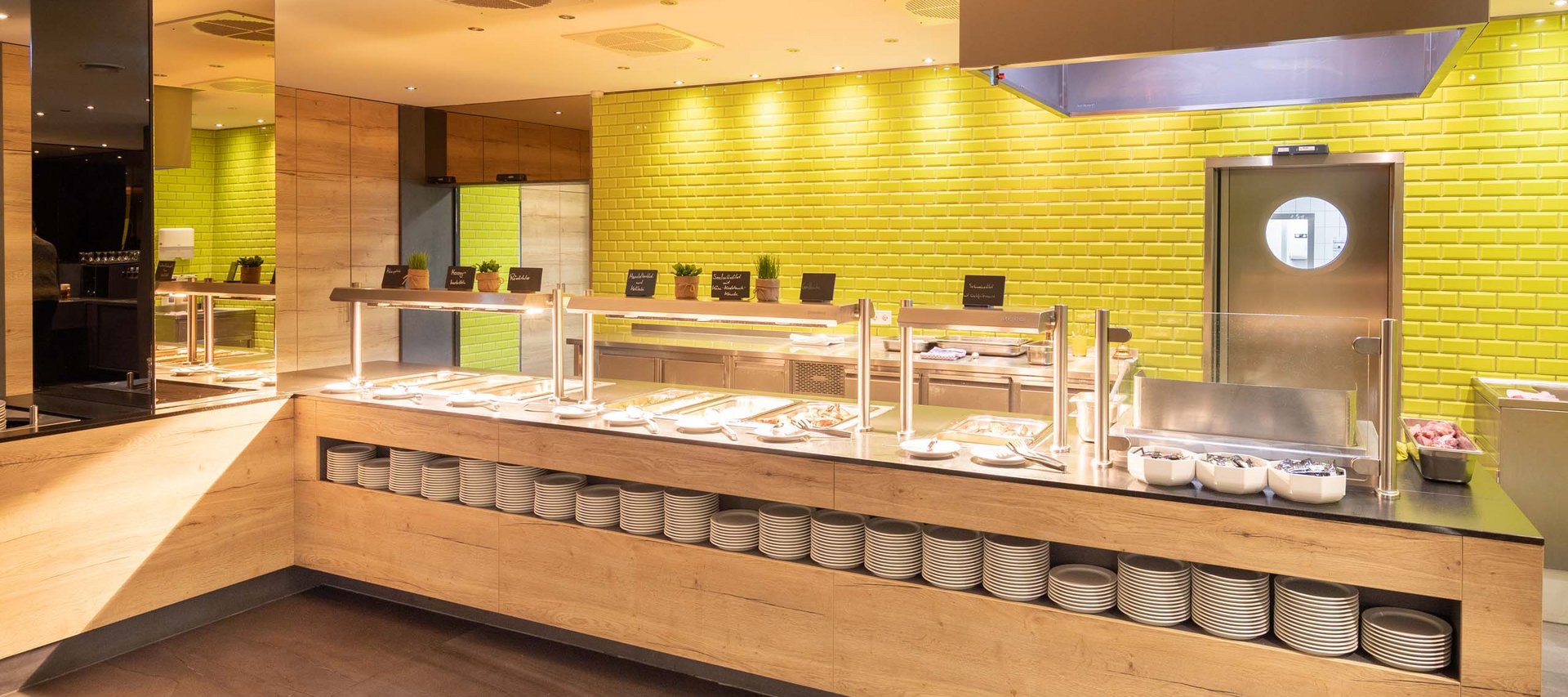 Ein Hotel in Jena mit All-inclusive-Verpflegung Helles Buffet mit Holzfront und gelben Kacheln im Hintergrund