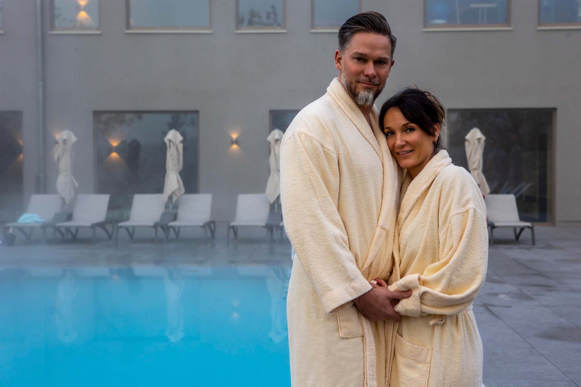 Day Spa in Jena: ein Tag nur für Sie Paar in Bademänteln umarmt sich neben beheiztem Außenpool