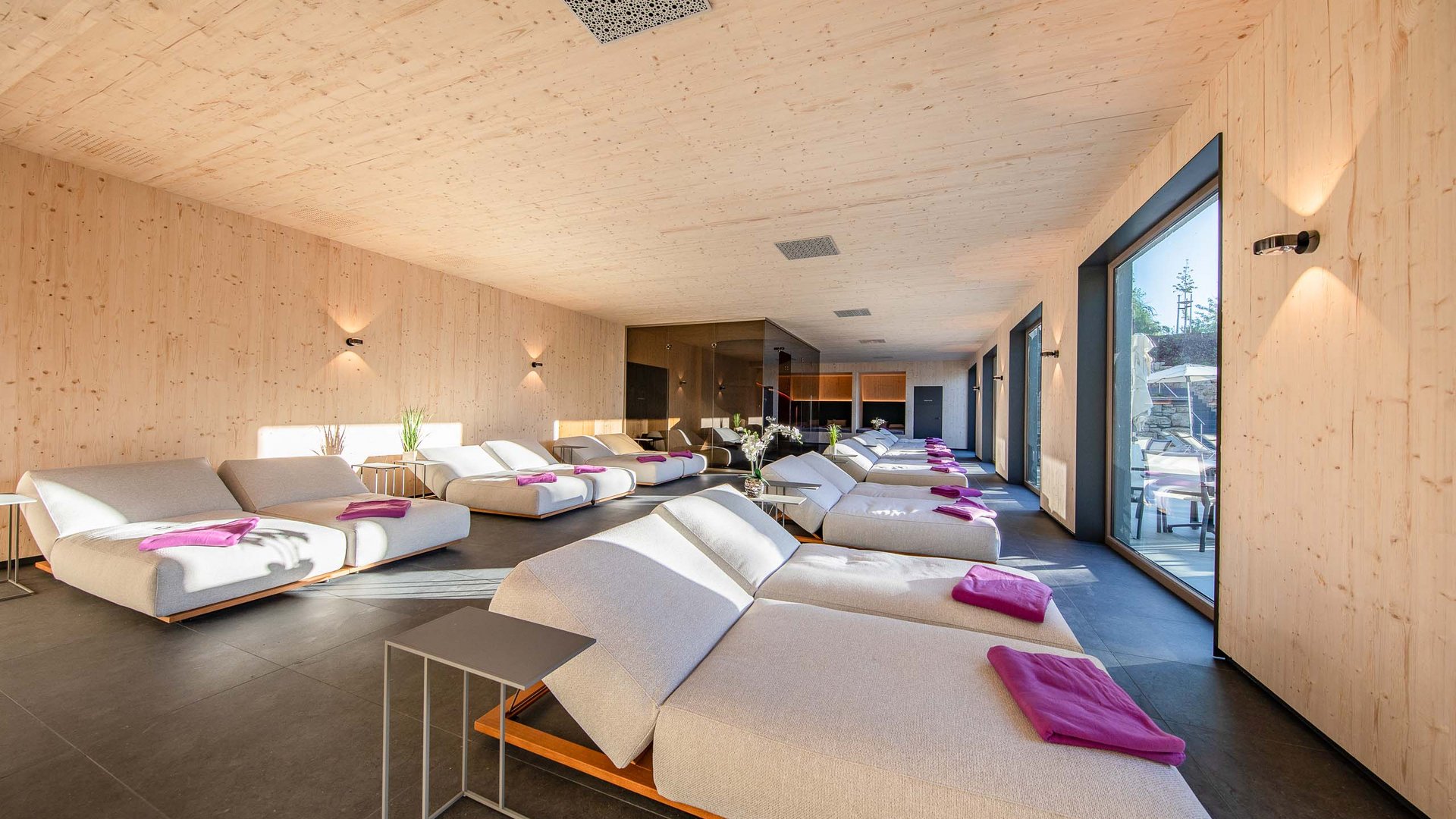 Das wohl beste Wellnesshotel in Thüringen Ruheraum mit modernen Liegen und lila Handtüchern in einem Wellnessbereich