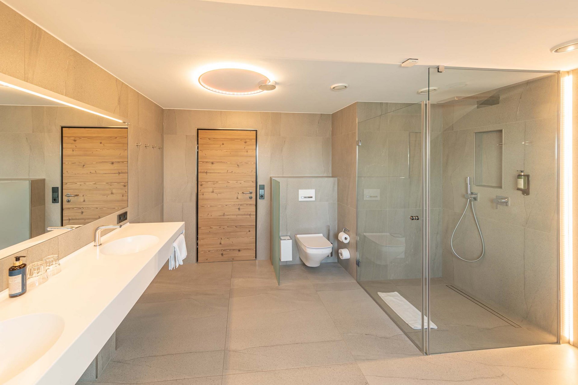 Wellness-Suite Modernes Badezimmer mit Doppelwaschbecken, Dusche und WC