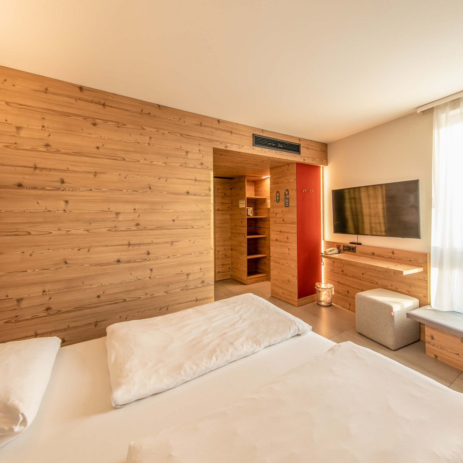 Das wohl beste Wellnesshotel in Thüringen Helles Hotelzimmer mit Doppelbett, TV und Holzwandgestaltung