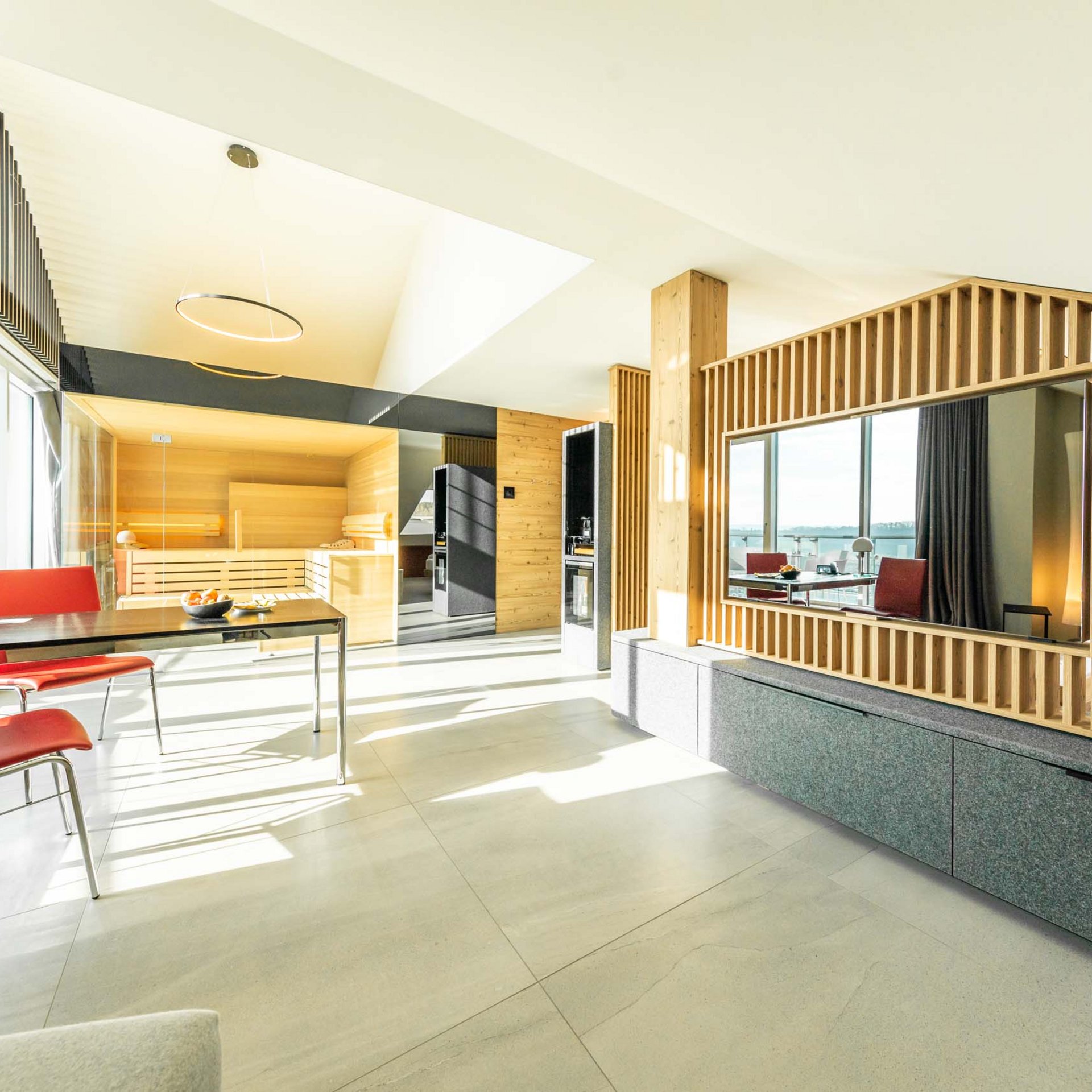 Wellness-Suite Heller moderner Raum mit rotem Stuhl, Tisch und Holzwänden