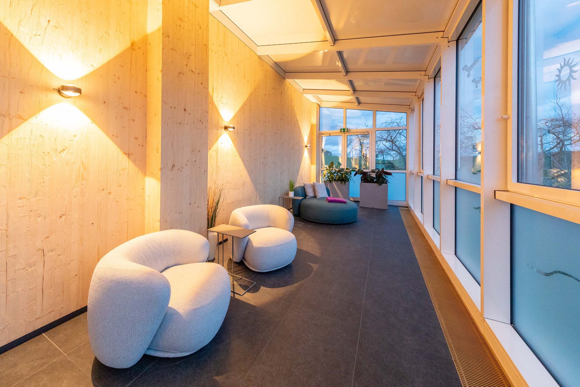 Das wohl beste Wellnesshotel in Thüringen Moderner Wartebereich mit bequemen Sesseln, Holzwänden und großen Fenstern